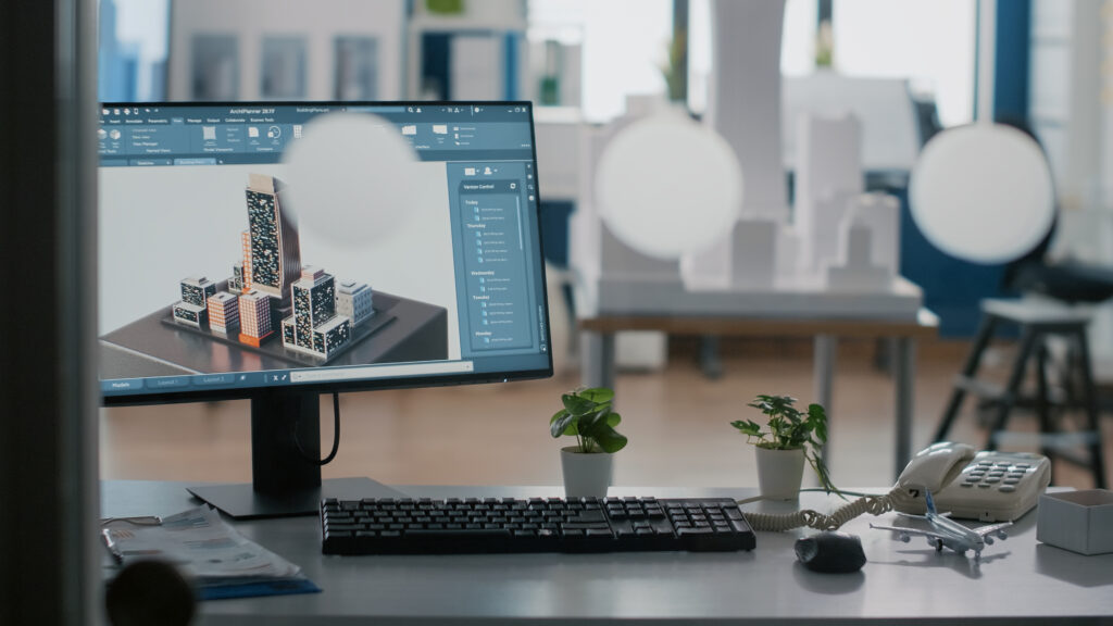 Close up of monitor with 3d building and construction layout on table ...